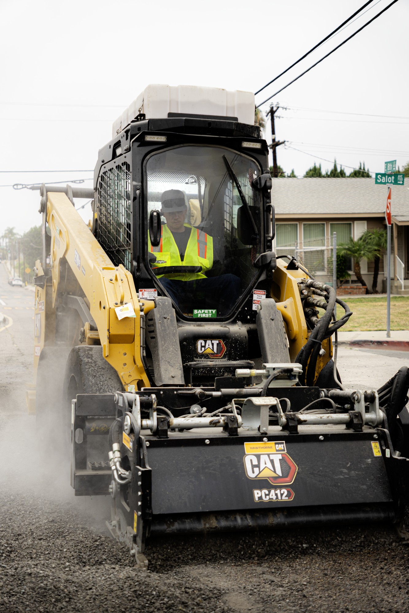 Equipment operator in a compact track loader with a pavement milling attachment
